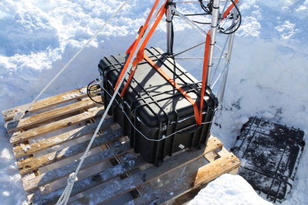 New battery box on its wooden pallet platform, and suspended by ratchet straps and rope and lashed to the tower.